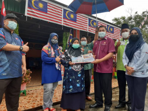 Pegawai Daerah Kulai Zainor Adani menyampaikan plak kepada pemilik rumah Mijor Paiman yang memenangi rumah patriotik.