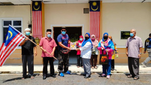 Khairul Haszezy Asni menerima sumbangan Jalur Gemilang daripada Pejabat Penerangan Daerah Alor Gajah yang disampai oleh ADUN Taboh Naning, Datuk Latipah Omar.
