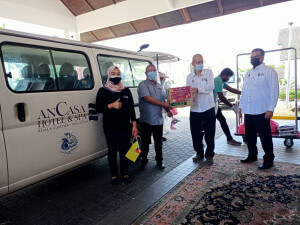 Haziz menyerahkan sumbangan bakul makanan kepada wakil pekerja hotel.