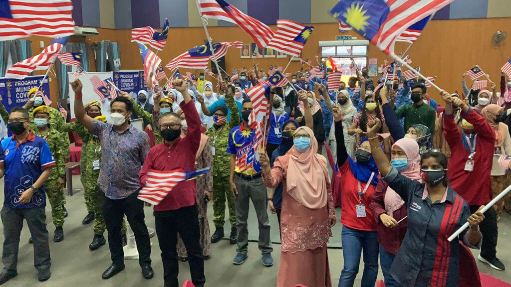 Petugas Barisan Hadapan Mengibarkan Jalur Gemilang di PPV Kompleks Sukan.