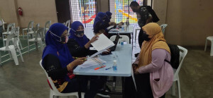 Proses pendaftaran berjalan lancar untuk penerima vaksin yang dikendalikan oleh petugas dari Jabatan Perpaduan.