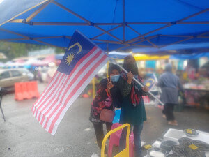 Gelagat peniaga pasar ketika agihan Jalur Gemilang di Pasar Besar Kemaman, semalam.
