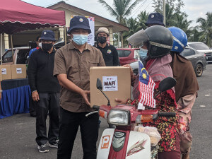 ADUN Pengkalan Berangan, Sulaiman Sulong menyerahkan kotak makanan kepada penerima yang terkesan dengan pandemik COVID-19.