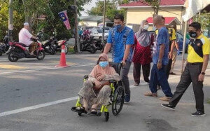 Hasnul menyantuni warga emas yang hadir menerima vaksin.