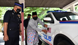 Khairul Shahril melekatkan Jalur Gemilang bermagnet pada kenderaan rasmi PDRM.