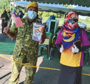 Rosni mengedarkan Jalur Gemilang kepada petugas PPV Dewan Kerian Permai.