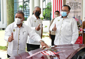 Menteri Besar Perak melekatkan magnet logo Malaysia Prihatin pada kenderaan.