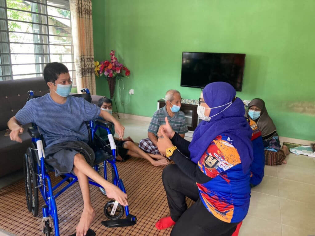 Hafizan menyantuni Idris yang menerima kerusi roda baharu dalam Program Sepakat@Komuniti Daerah Hulu Langat semalam.