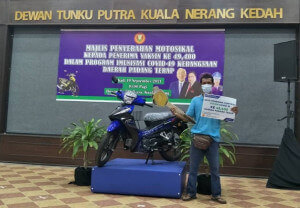 Mohd Isham, penerima vaksin yang ke 49,400 bersama motosikal yang berjaya dimilikinya.