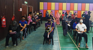 Para pelajar sedang menunggu giliran bagi menerima suntikan vaksin di PPV Dewan Serbaguna Permai Selama, di sini semalam.