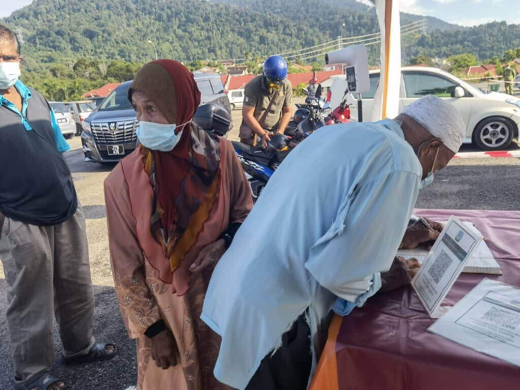 Pengunjung sedang menulis nama bagi yang tidak mempunyai MySejahtera.