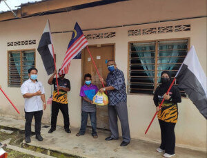 Ahli Parlimen Cameron Highlands (baju batik) mengedarkan Jalur Gemilang, bendera Negeri Pahang serta bantuan bakul makanan.