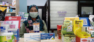 Rabiatuladawiah, seorang pemilik farmasi bumiputera menunjukkan jenis kit ujian COVID-19 yang boleh didapatkan di farmasinya. 
