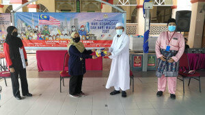 Maria Che Mat Nawi@Muhammad Nawi menyerahkan Jalur Gemilang kepada wakil Masjid Al-Qurtubi.