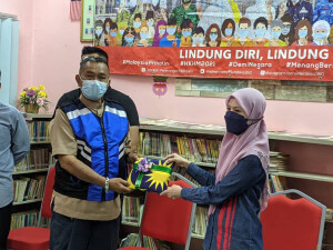 Penolong Pengarah Cawangan Media Siber JaPen WPKLP, Tengku Nor Liza Tengku Yahya menyerahkan Jalur Gemilang kepada penduduk.