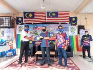 Lim Ann Teck menyerahkan Jalur Gemilang kepada wakil penduduk sebagai simbolik menyemarakkan sambutan Hari Malaysia.