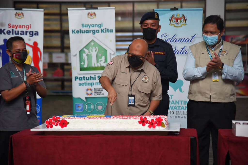 Aminuddin memotong kek sempena sambutan Hari Malaysia di PKRC Bersepadu MAEPS 2.0.