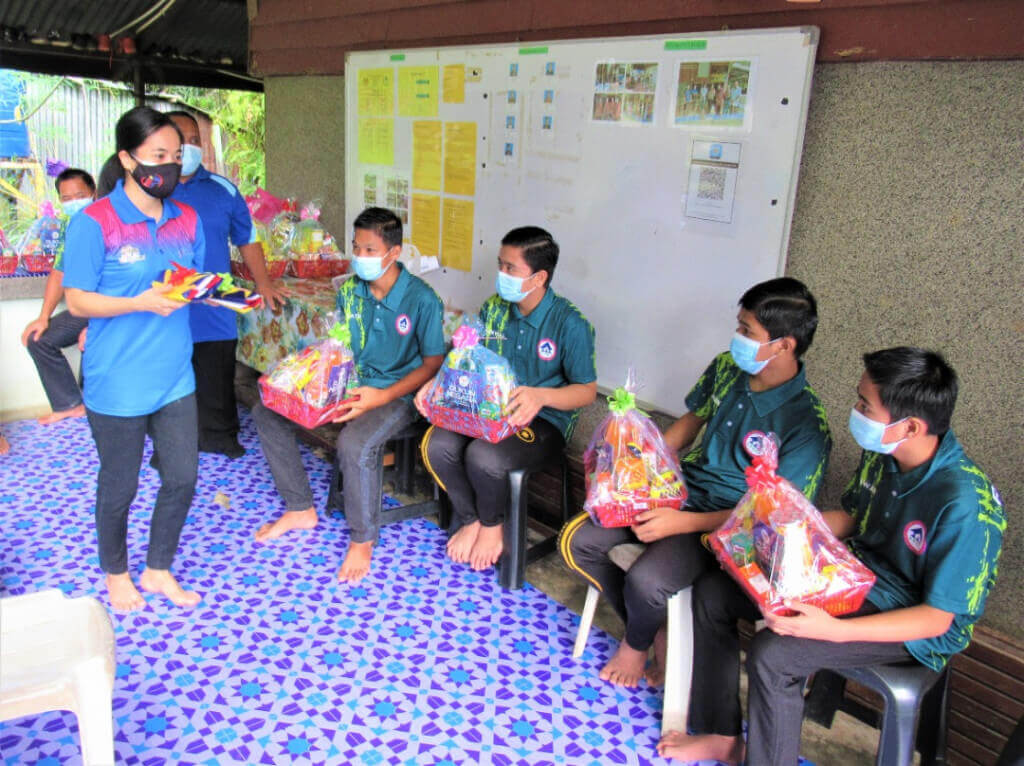 Melanie ketika menyampaikan sumbangan berupa bakul makanan dan Jalur Gemilang kepada anak-anak yatim Al-Ehsan.