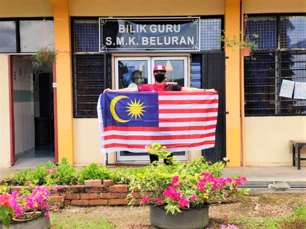 BANGGA…Albinus Joseph Silou bangga memegang Jalur Gemilang yang akan dipasang di Bilik Guru SMK Beluran Bestari.