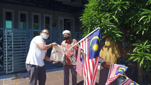 Asdazairi menyampaikan beg cenderamata kepada penduduk setempat di Taman Bukit Cheras.