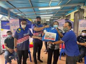 Penerima menerima sumbangan daripada tetamu kehormat yang hadir semasa Program Sepakat@Komuniti Peringkat Parlimen Putrajaya dengan kerjasama Persatuan Penduduk Perumahan Awam Fasa 1C, Presint 16.