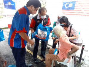 Lim Ann Teck menyerahkan sumbangan bakul makanan kepada penduduk.