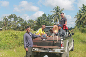 Jimbat (kiri) bersama jiran kampung yang membantu menuai padi pada tanah 2 ekar.