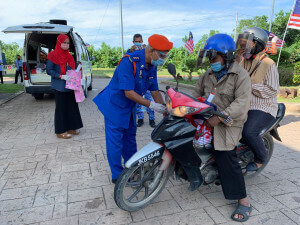 Pegawai Angkatan Pertahanan Awam turut menyampaikan Jalur Gemilang buat orang ramai yang hadir bagi tujuan vaksinasi di PPV Taman Tamadun Islam (TTI), baru-baru ini.