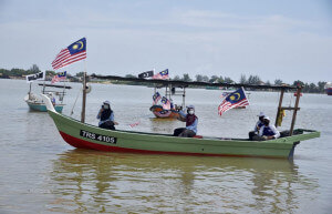 Perarakan nelayan pantai mengibarkan Jalur Gemilang.