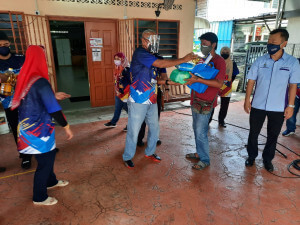 Bendera, kit pencegahan COVID-19 dan kotak makanan diberikan kepada penerima terpilih semasa persinggahan di semua lokasi Konvoi.