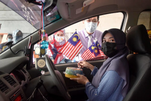 Dr Tan Sin Yew dan Puan Adawiyah Othman mengedarkan Jalur Gemilang serta cenderahati kepada penerima vaksin.