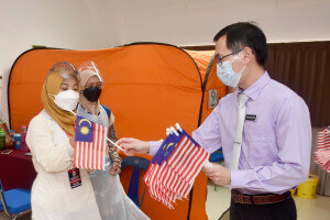 Dr Tan Sin Yew mengedarkan Jalur Gemilang kepada petugas-petugas PPV, Bukit Payong.