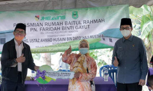 Replika kunci sedang disampaikan kepada Puan Faridah.