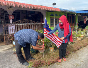 Mohd Samsul Alias memasang bendera Malaysia sebagai simbolik perasmian.
