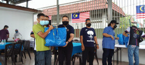 Affendi (tiga dari kiri) mengiringi Asdazairi pada majlis penyerahan sumbangan bakul makanan.