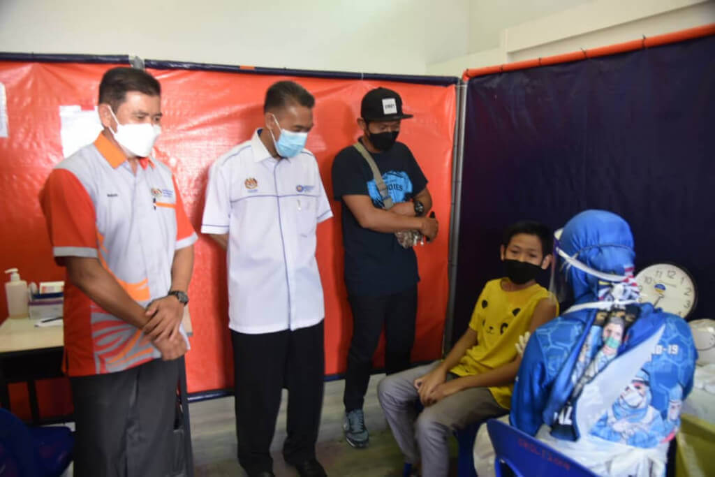 Pengarah Jabatan Pendidikan Labuan, Yusuf Mohamad (dua dari kiri) meninjau proses pemberian vaksin di PPV tersebut.