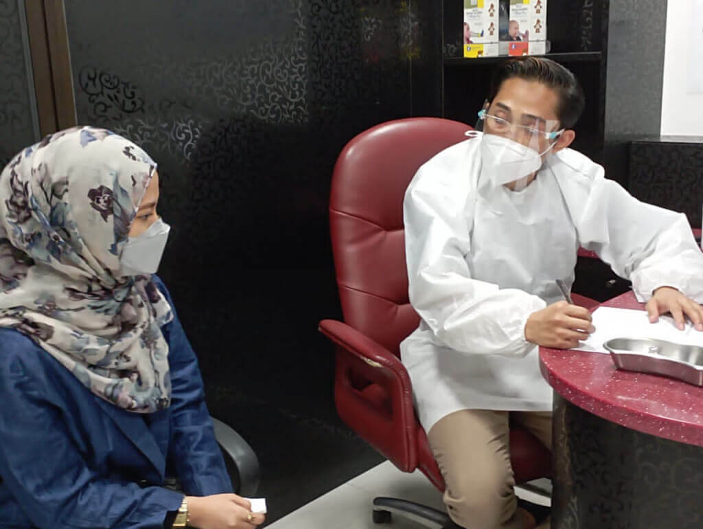 (Kanan) Dr Mohammad Miqdam memberikan konsultasi sebelum disuntik dos penggalak.