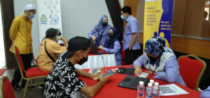 Kakitangan PERKESO membantu pencari kerja yang hadir.