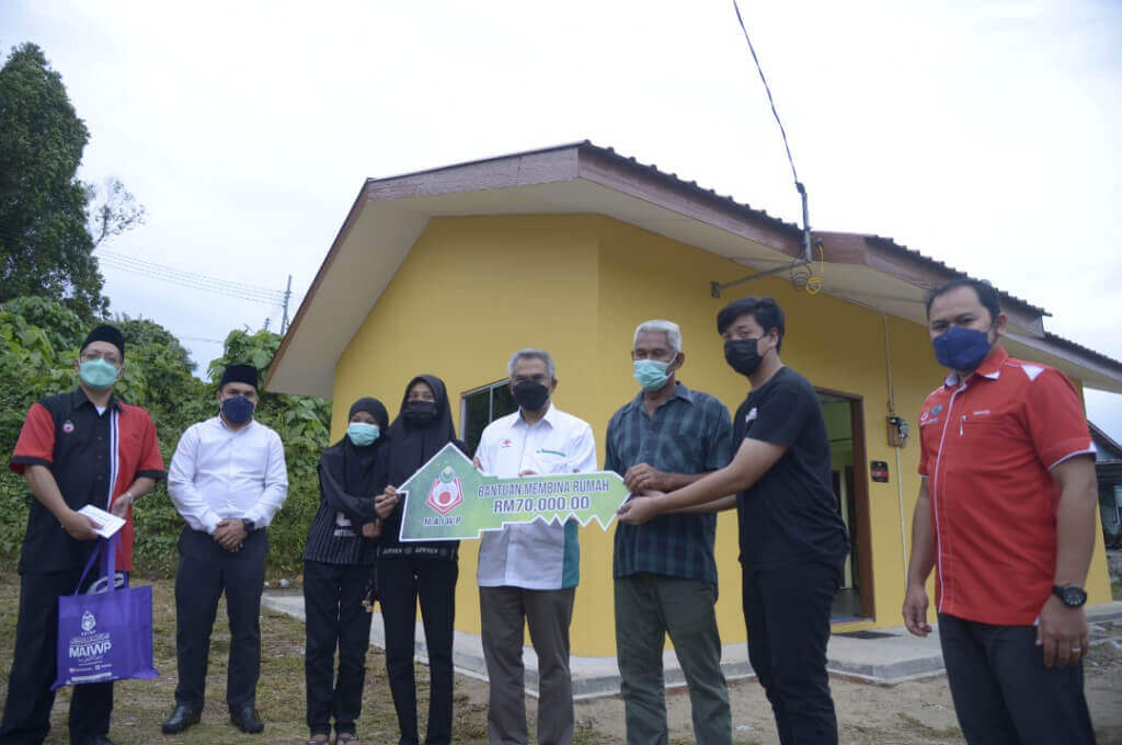 Dr. Mohd Daud (empat dari kanan) bersama Saidin Salim (tiga dari kanan) semasa majlis penyampaian rumah bantuan MAIWP.