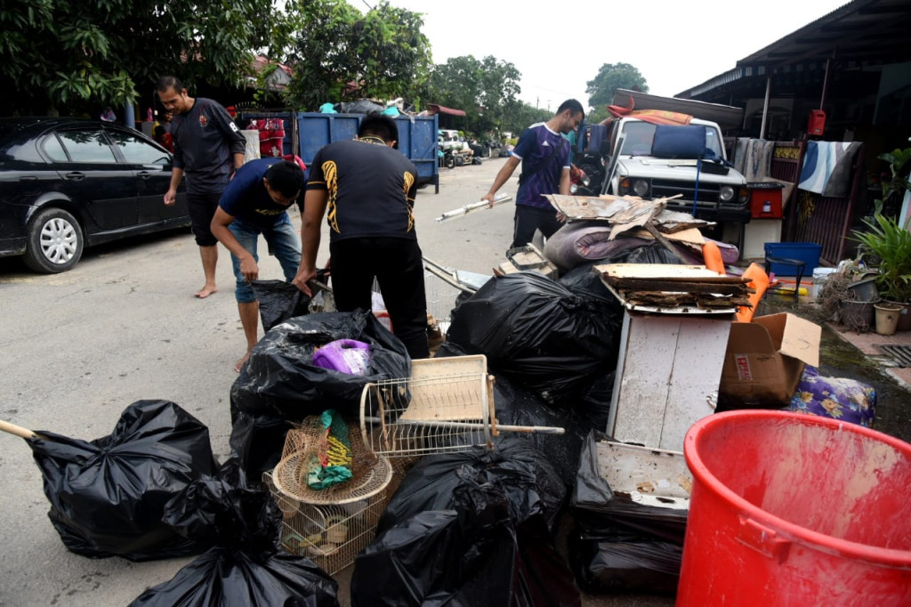 Sukarelawan sedang membantu membersihkan rumah mangsa banjir Taman Sri Putri Meru Klang antara kawasan yang paling terjejas di Meru.