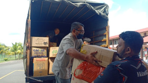 Zan Aizuwan (kanan) membantu para sukarelawan mengangkat barangan sumbangan ke dalam lori.