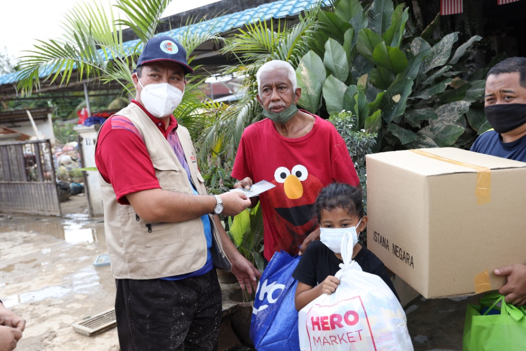 (Dari kiri) Dr Mohd Zahari menyampaikan sumbangan kepada salah seorang mangsa banjir di Sri Nanding.