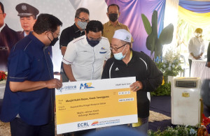 Mohd Zuki menyampaikan sumbangan RM10,000.00 kepada wakil Masjid Kampung Bukit Bayas pada program Jalinan Kasih Keluarga Bersama Ketua Setiausaha Negara di Sekolah Kebangsaan Bukit Bayas, Kuala Terengganu.